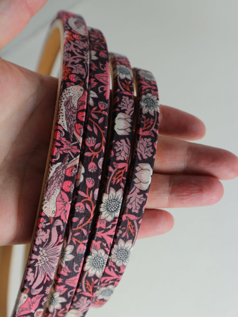 Close up of embroidery hoop wrapped in Pink 'Strawberry Thief' fabric, 'Strawberry Thief' fabric was designed by William Morris, a name famous within the Arts and Crafts movement.
