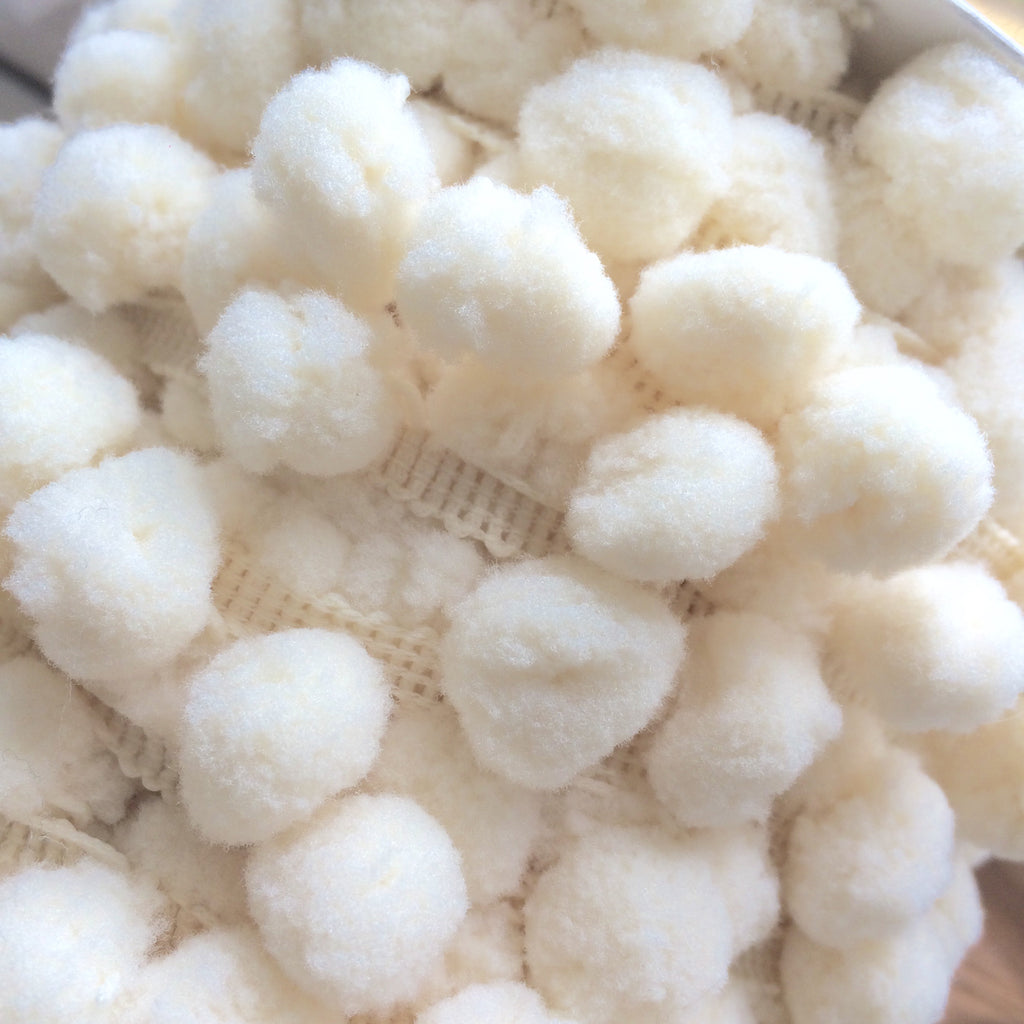close up of cream Pom pom trim