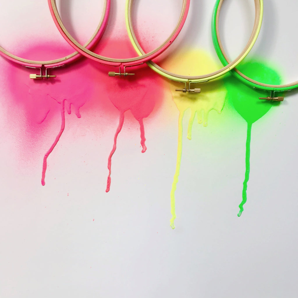 collection of neon painted embroidery hoops painted in  four colours