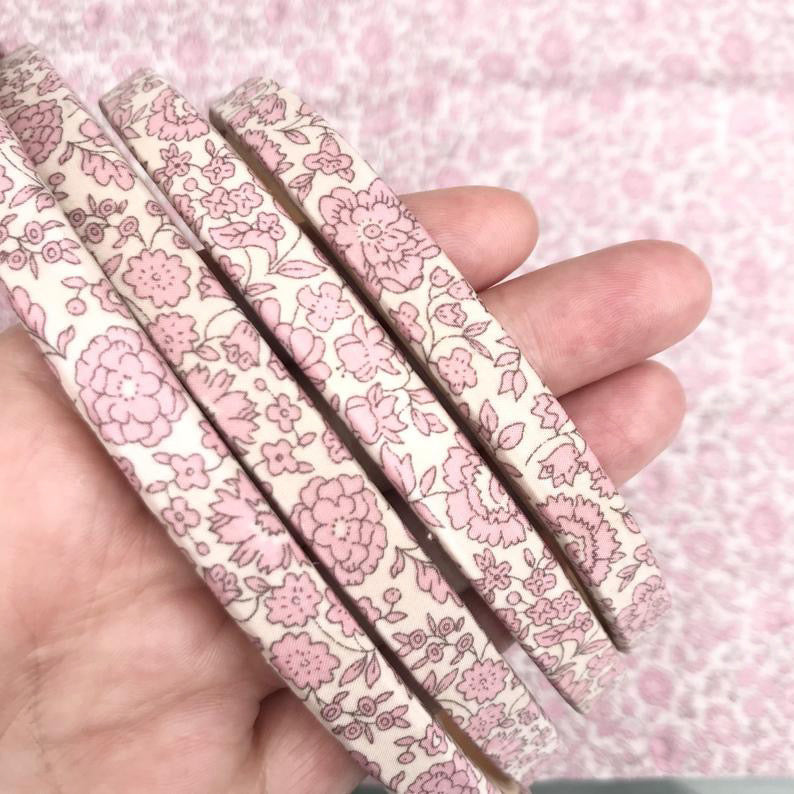 Pastel pink embroidery hoops with hand for scale