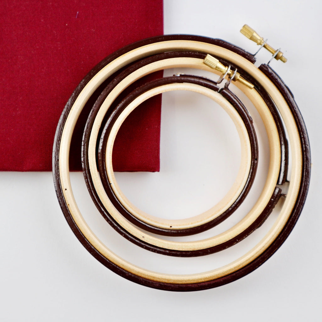 coloured black red embroidery hoop with a red fabric background.