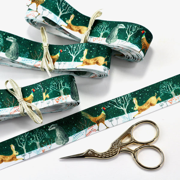 Bundles of dark green satin ribbon with woodland animals.