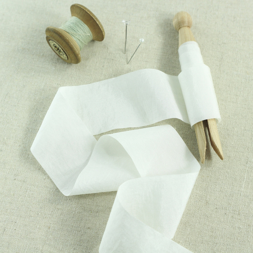 white wedding ribbon on a vintage wooden peg.
