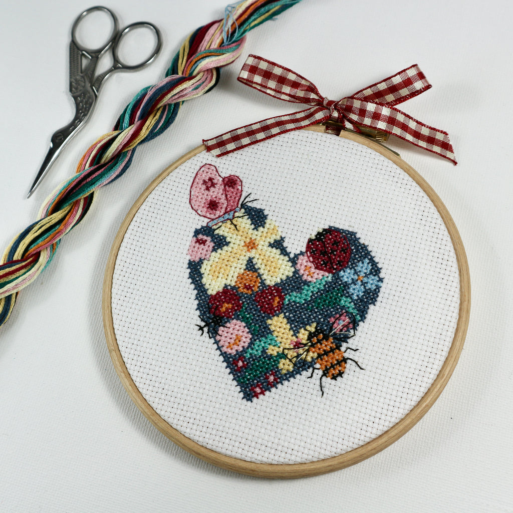 Love heart cross stitch in embroidery hoop, with flowers, berries and insects.