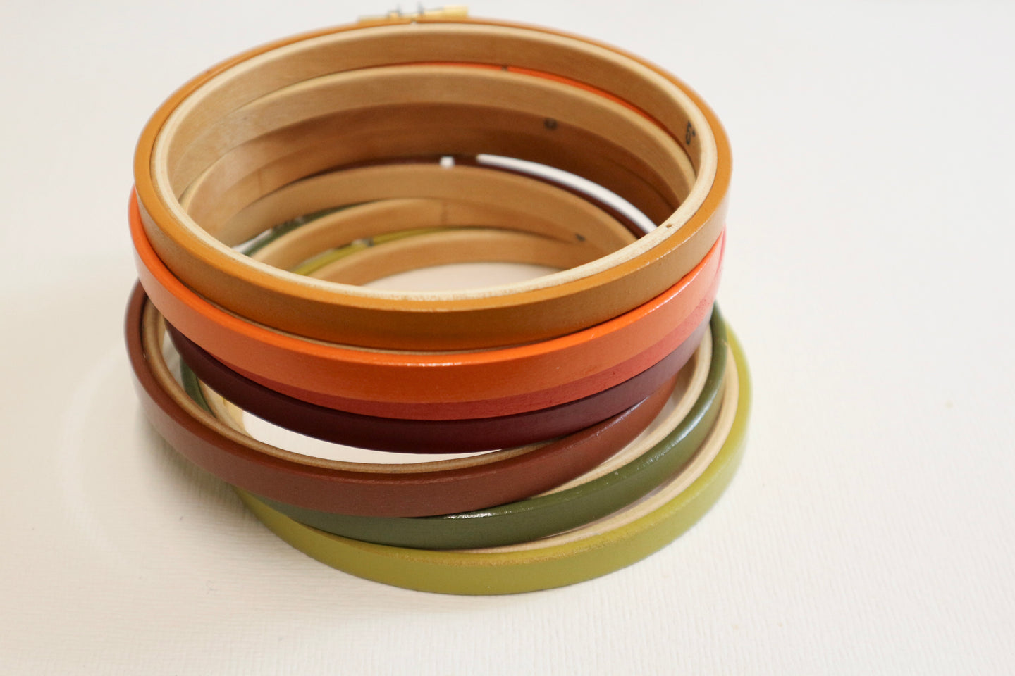Stack of colorful embroidery hoops on a light background