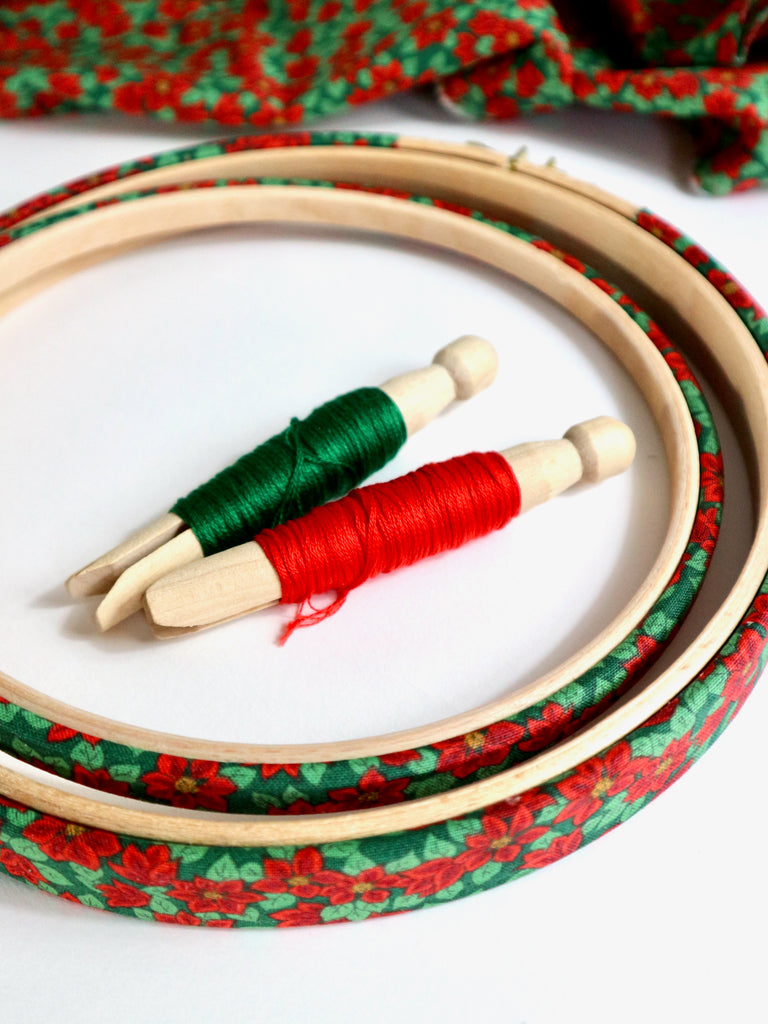 Embroidery hoops with red and green thread on a white background