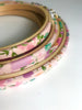 Set of embroidery hoops with floral patterns on a light pink background