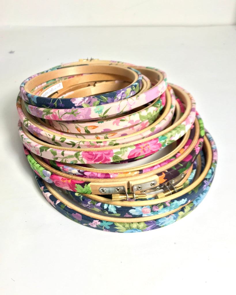 Stack of floral-patterned embroidery hoops on a white background