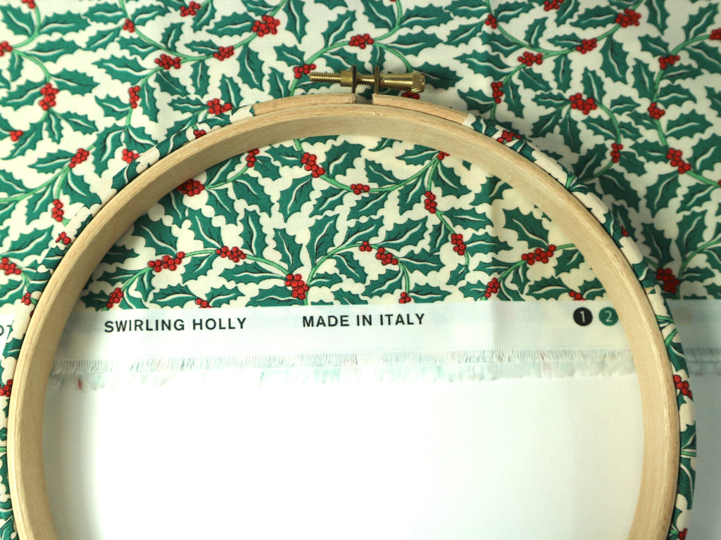 Embroidery hoop with holly pattern fabric and 'Made in Italy' label