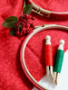 Embroidery hoops with red and green thread on a red fabric background