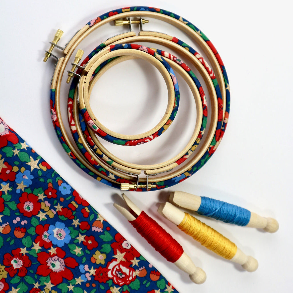 many blue decorative embroidery hoops with embroidery threads.