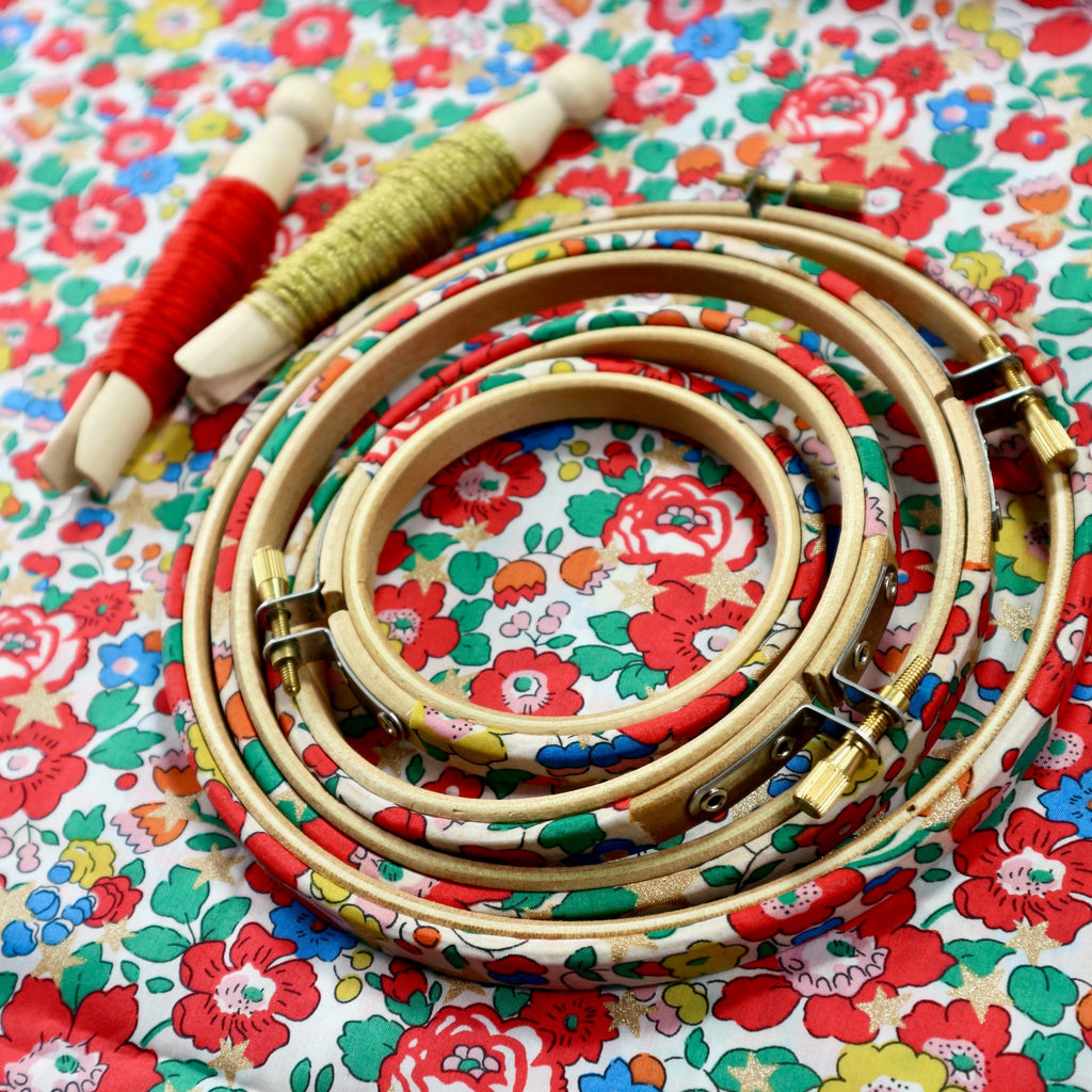 Pretty embroidery hoop frames with metallic stars and embroidery threads.