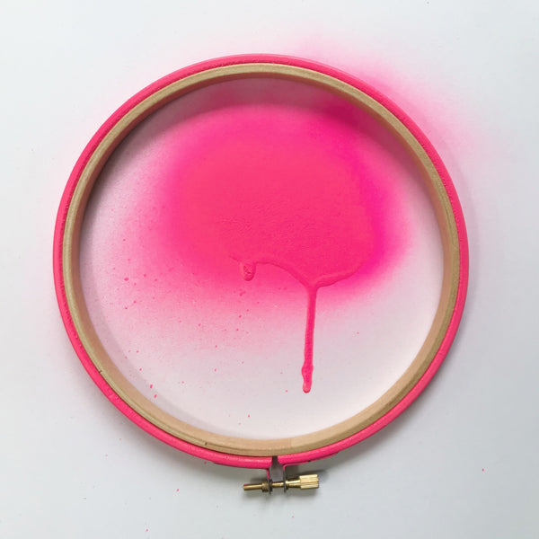 Neon pink embroidery hoop with spray paint