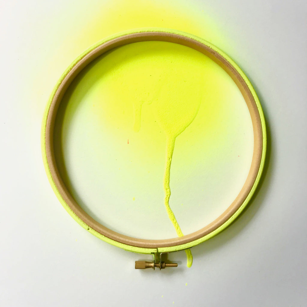 Neon yellow embroidery hoop with spray painted background