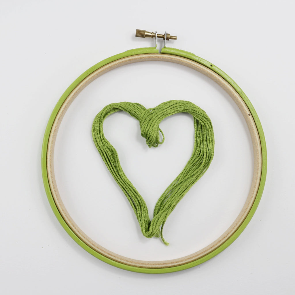 Embroidery thread, green heart with green embroidery hoop.