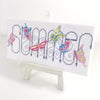 Summer cross stitch, finished on a artist canvas displayed on as artists easel. 