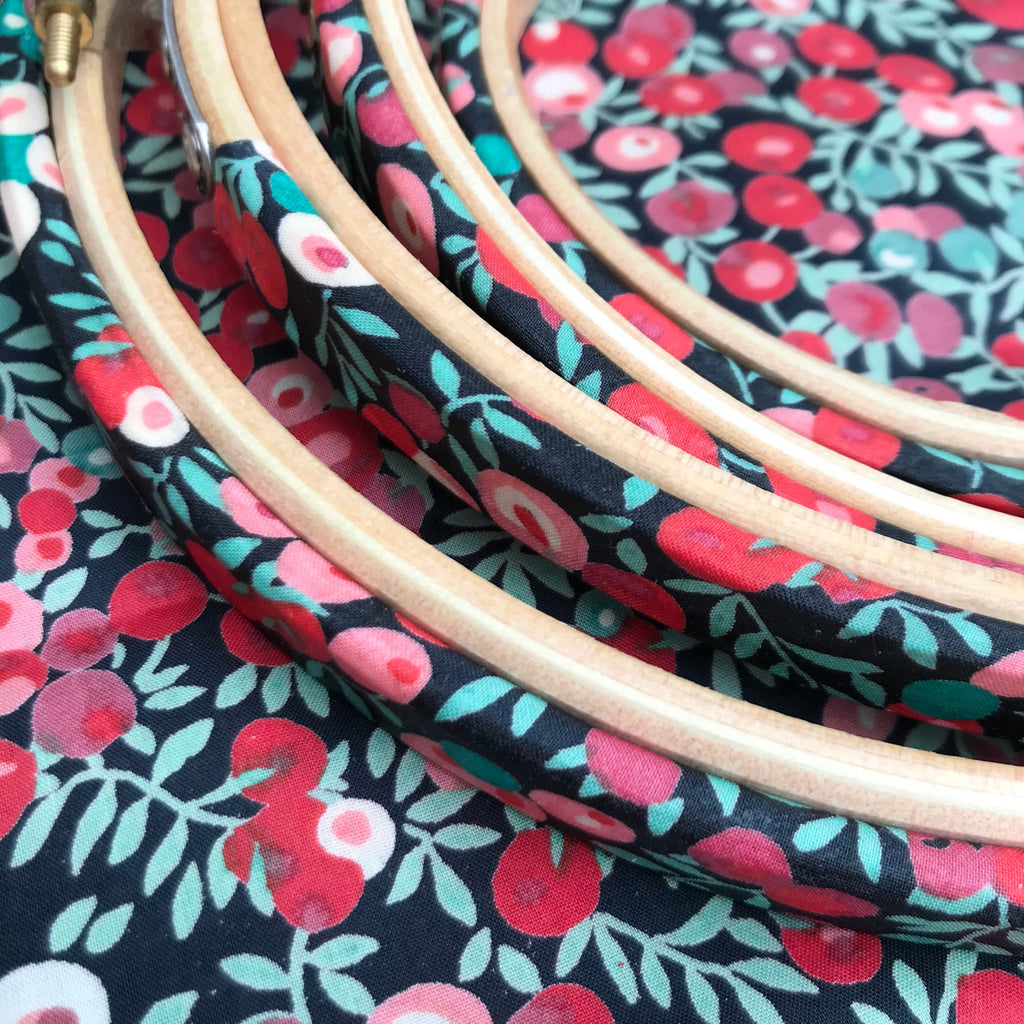 close up of decorative embroidery hoops with red berries. 