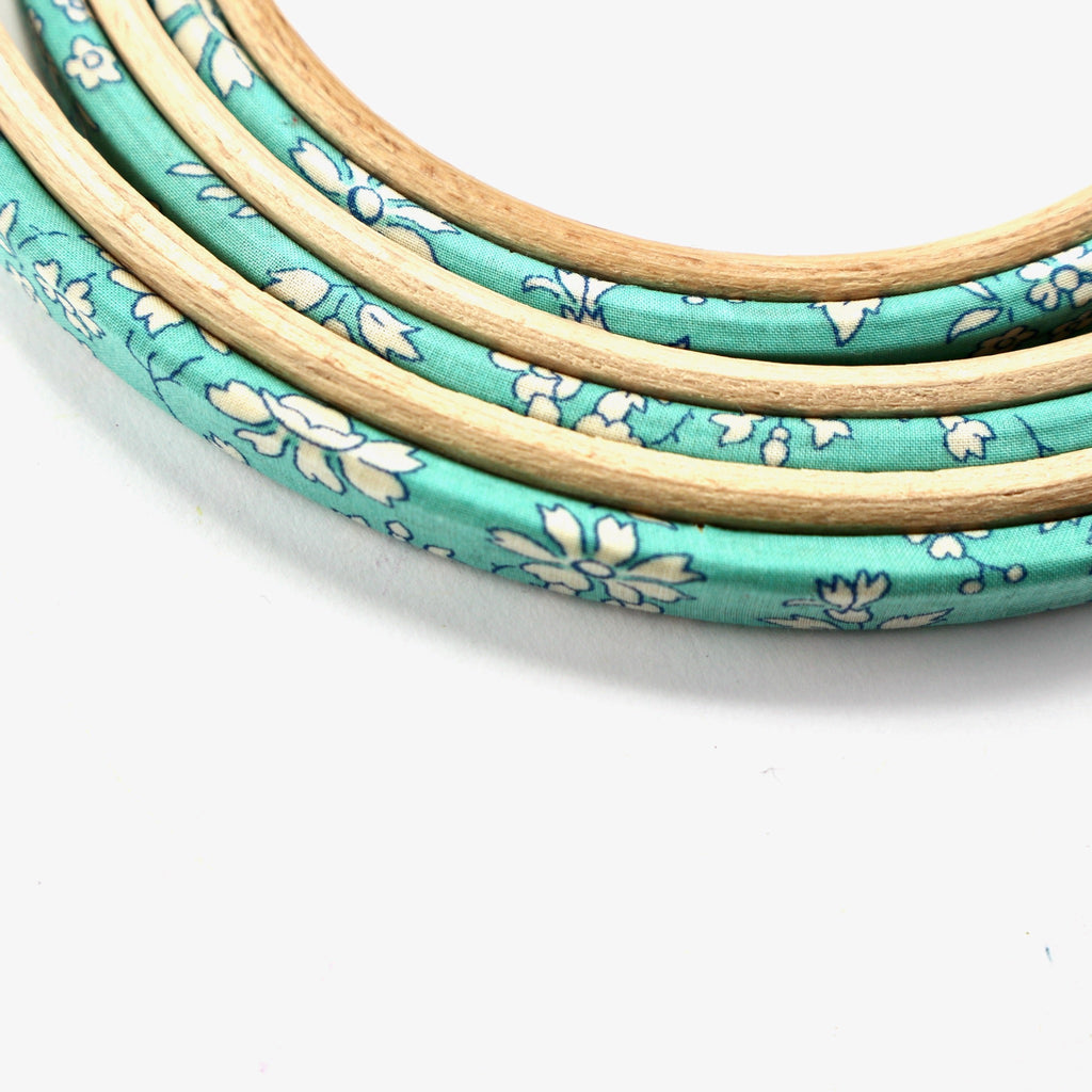embroidery hoops covered in turquoise Capel Tana Lawn cotton.