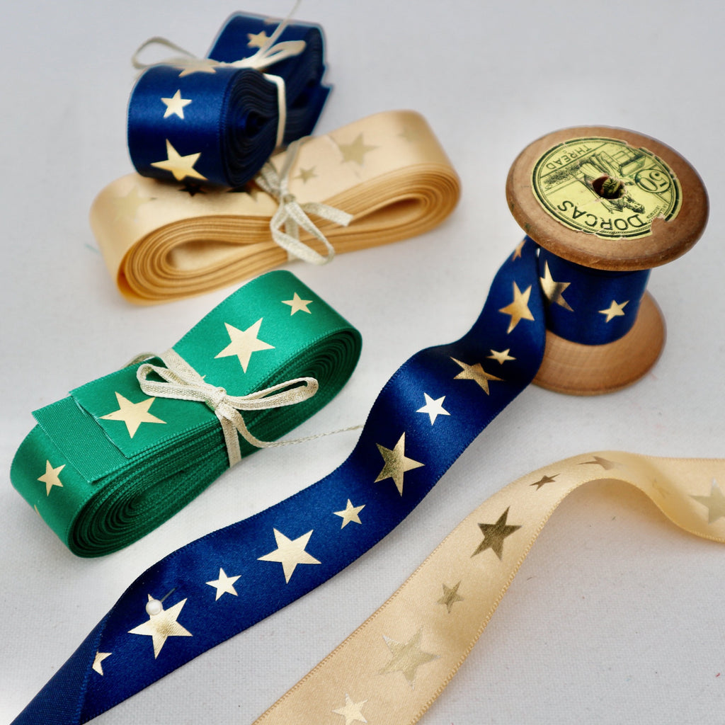 Satin christmas ribbon with golden stars. Some ribbons in bundles and on cotton reels.