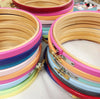 stack of coloured embroidery hoops. brightly painted embroidery hoops.