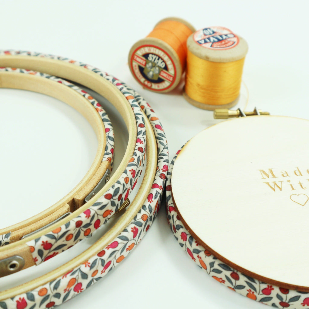 embroidery hoops covered with orange and red berry fabric