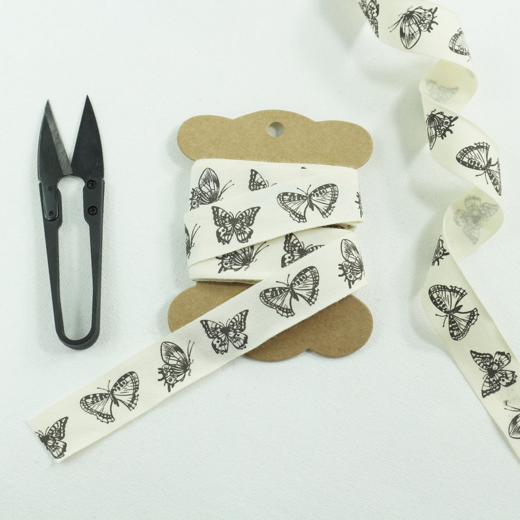 20 mm wide, ivory cotton tape with butterfly print on Kraft bobbin.