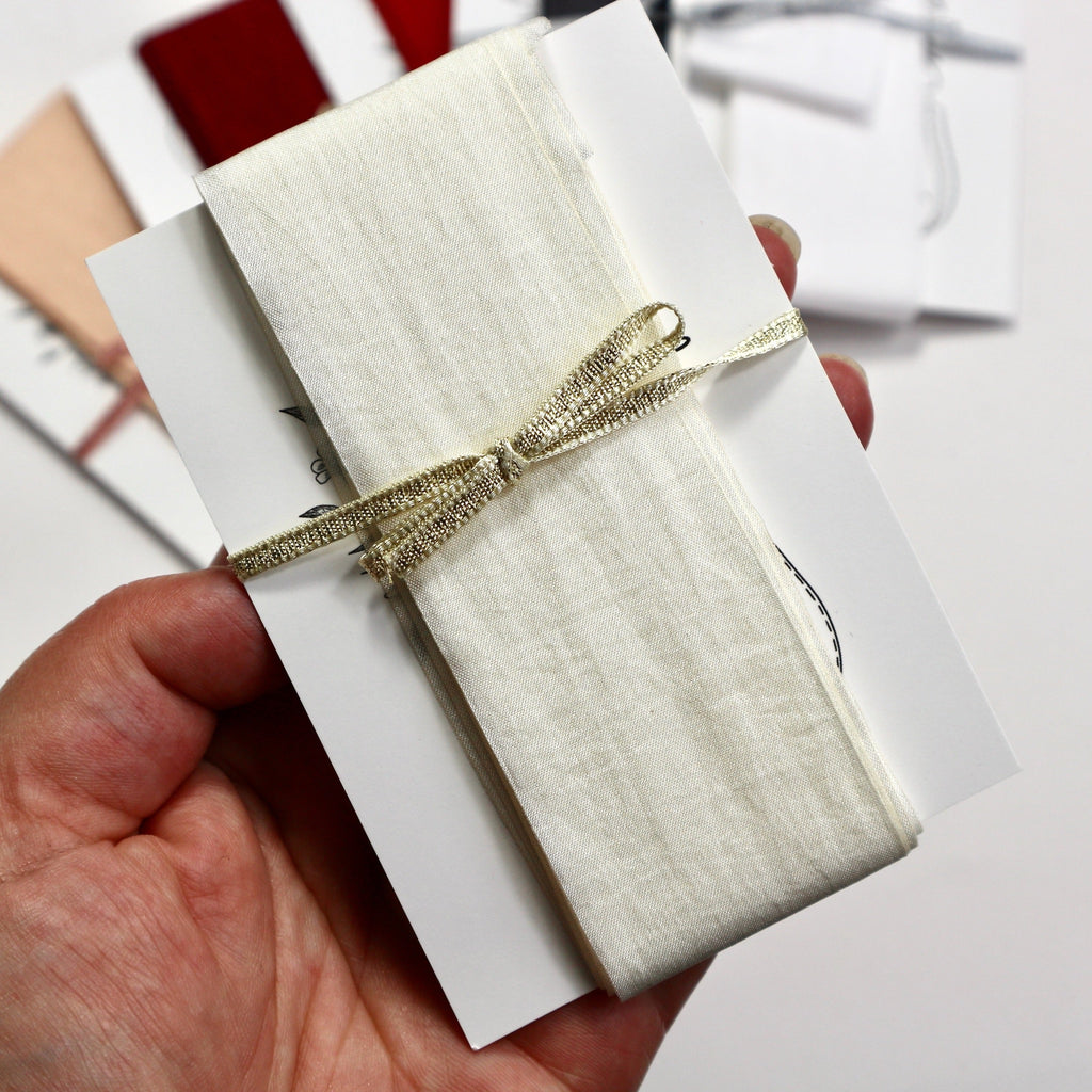 Ivory coloured faux silk ribbon on a card.