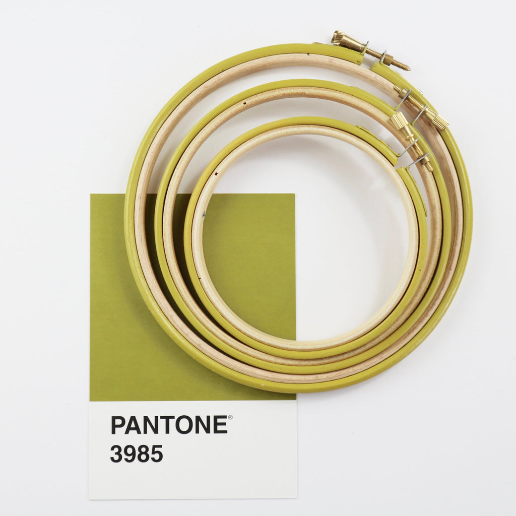 Mustard green embroidery hoops with a Pantone colour swatch.
