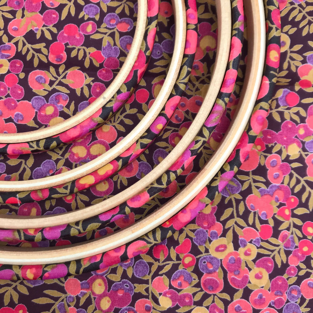Wooden embroidery hoops on a floral fabric background
