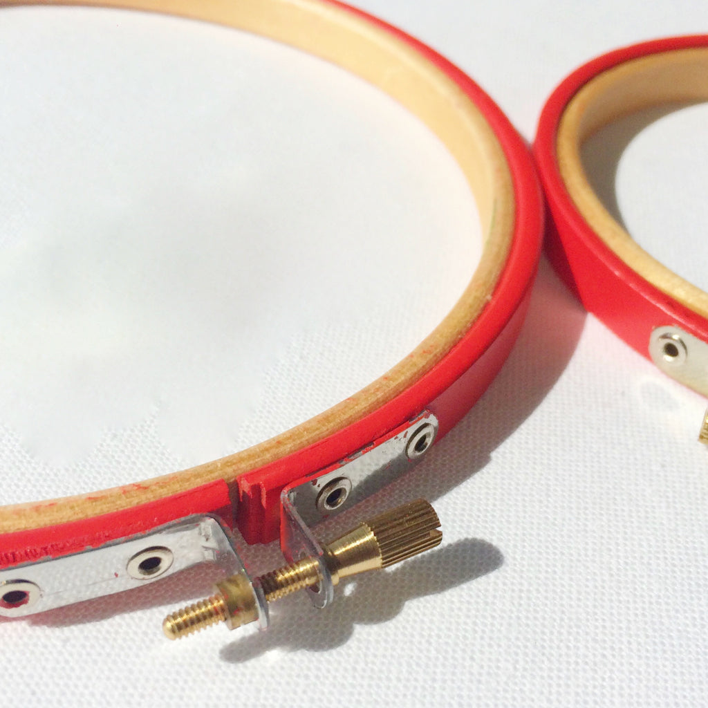 Close up of bright red embroidery hoops.