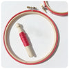 bright red embroidery hoops with thread bobbin.