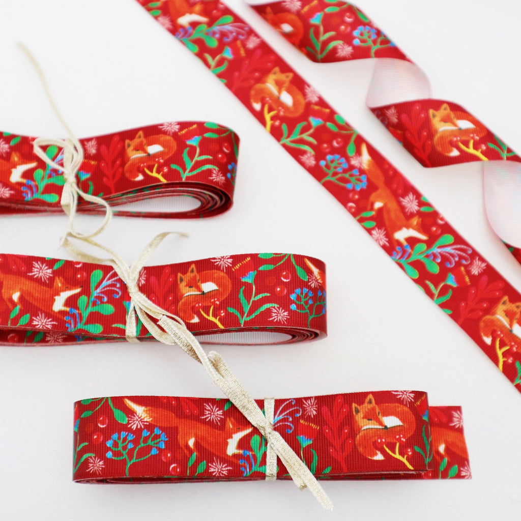 5 meters of 25mm red fox ribbon, tied with a gold ribbon bow 