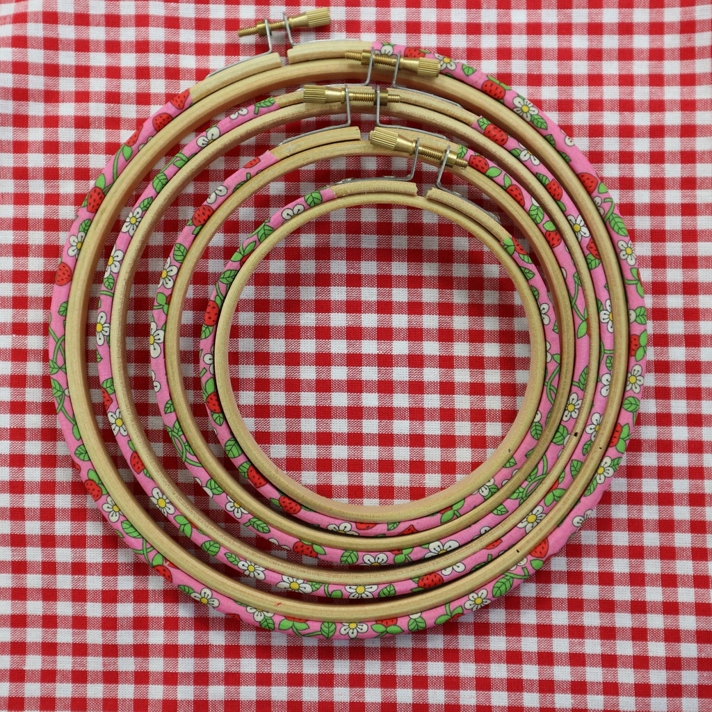 red, pink and green embroidery hoops on red gingham fabric.