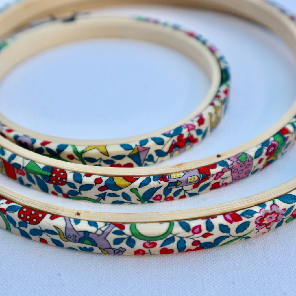 Embroidery hoops with colorful floral pattern on a white background